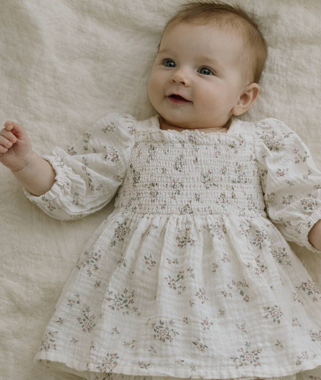 Babymodel in festlichem Musselin Babykleid mit Blumendruck