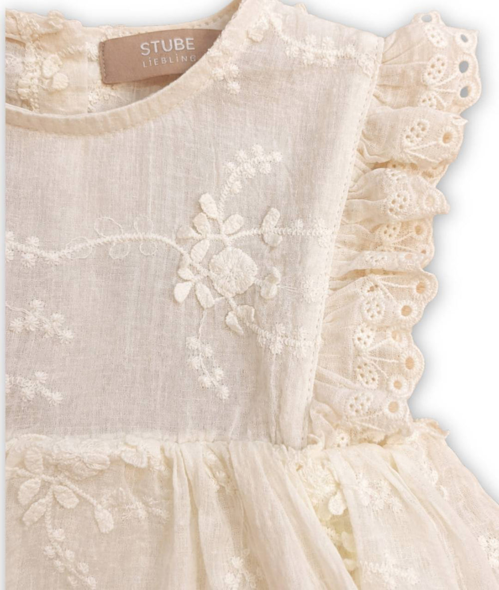 Detailansicht des hellen festlichen Babykleides mit Spitzen