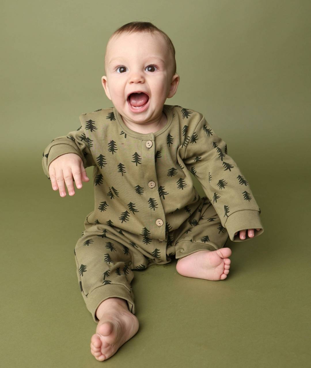 Tannenpyjama an Baby sitzend
